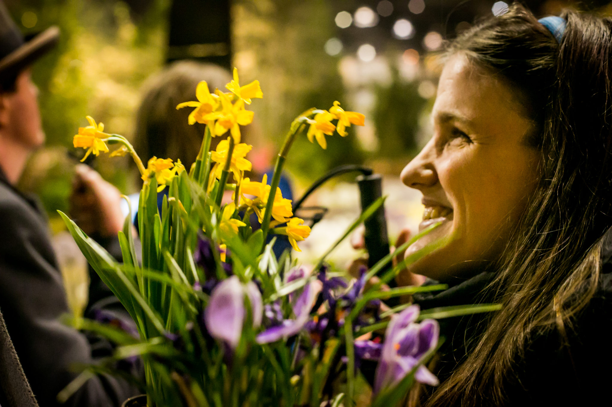A woman smiles, standing next to flowers at the 2015 Philadelphia Flower Show.