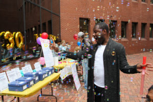 A man laughs as he is surrounded by bubbles at Art-Reach's 30th birthday party.