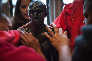 A group of blind visitors to the Rodin Museum touch a replica of a statue while on a touch tour.