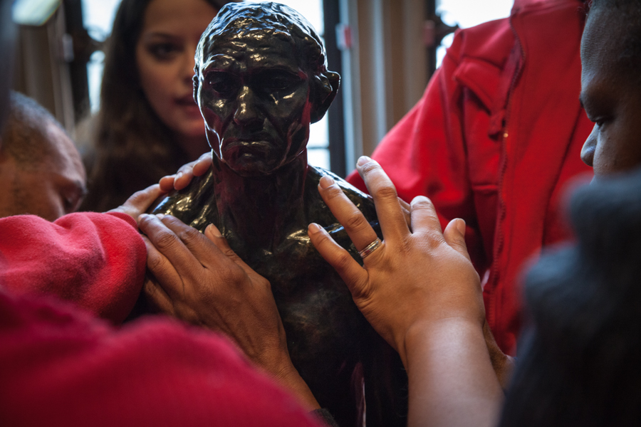 A group of blind visitors to the Rodin Museum touch a replica of a statue while on a touch tour.