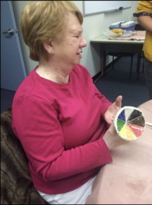 A woman holds a colourful object at the Library for the Blind and Physically Handicapped.