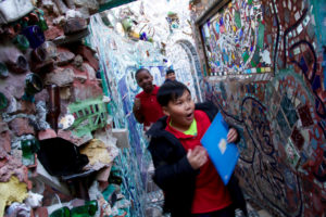 A boy walks excitedly through a corridor at Philadelphia's Magic Gardens.