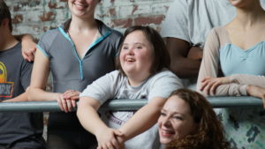 Saint Katherine Day School student leans on a ballet barre, smiling, surrounded by PA Ballet dancers.