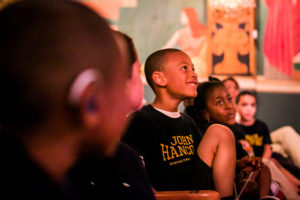 A boy smiles while looking up.