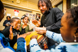 Art-Reach in-facility artist Tony Mascara drums with a group of children.