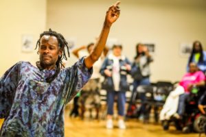 A man raises his left arm while dancing.