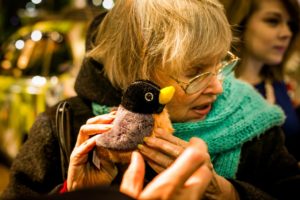 a woman feels a plushie bird at the 2017 flower show.