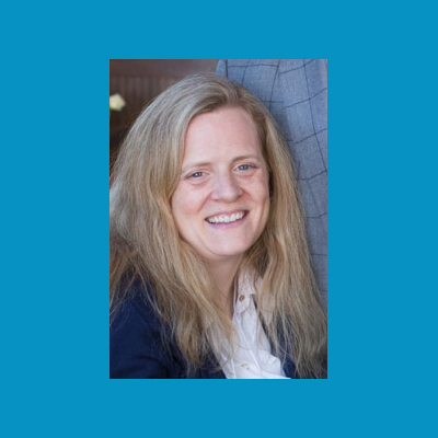 portrait of Katie Samson smiling with a blue background