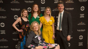 Photo of staff infront of step and repeat