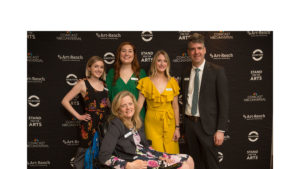 Photo of staff infront of step and repeat