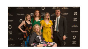 Photo of staff infront of step and repeat