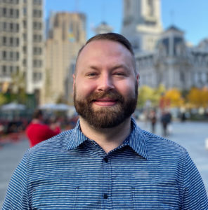 Portrait of Charlie Miller outside with Philadelphias City Hall in the background