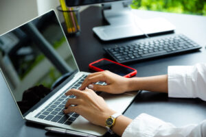 Hands typing on laptop